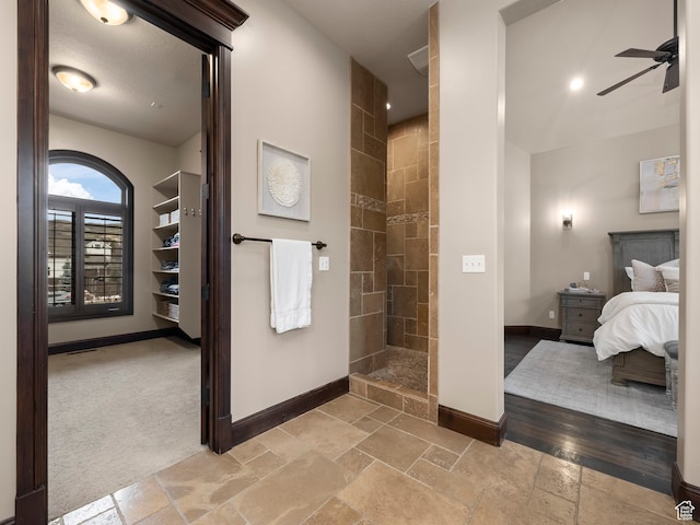 bathroom featuring ceiling fan and tiled shower