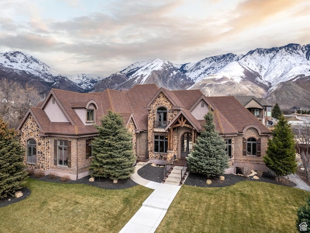 view of front of home with a mountain view and a front lawn