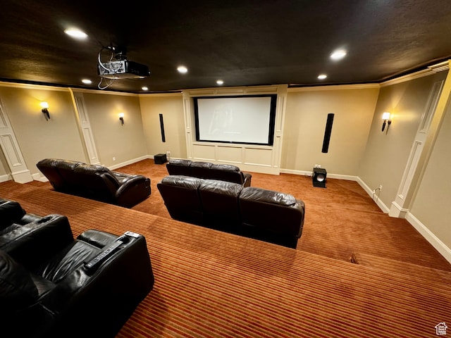 carpeted home theater room featuring crown molding