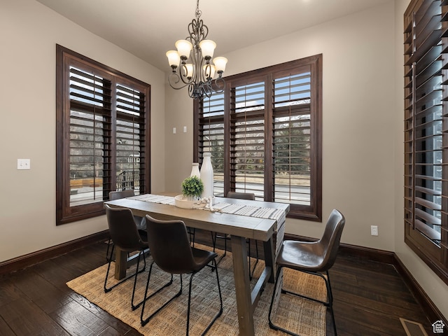 dining area with a notable chandelier and dark hardwood / wood-style floors