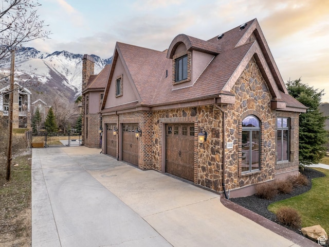 property exterior at dusk with a garage and a mountain view