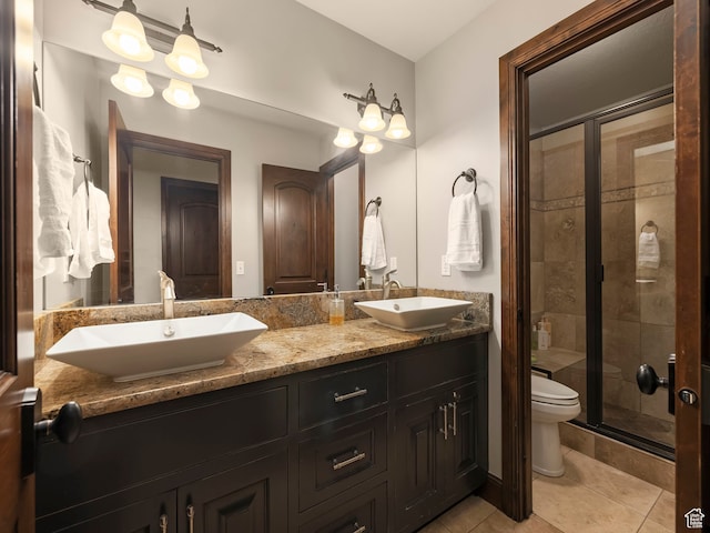 bathroom featuring tile patterned floors, toilet, a shower with door, and vanity