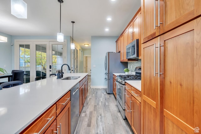4489 W Milford Dr, South Jordan, UT 84009 - kitchen with a sink, light countertops, stainless steel appliances, light wood-type flooring, and pendant lighting