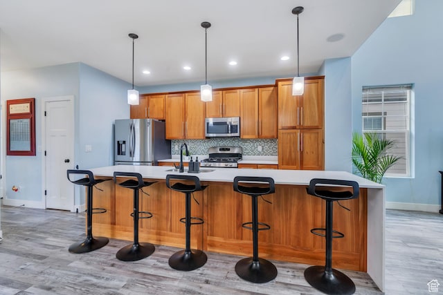 4489 W Milford Dr, South Jordan, UT 84009 - kitchen featuring baseboards, light wood-style floors, light countertops, a sink, and stainless steel appliances