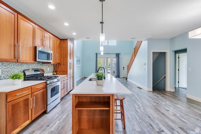 4489 W Milford Dr, South Jordan, UT 84009 - kitchen with a sink, light wood-style floors, french doors, stainless steel appliances, and backsplash