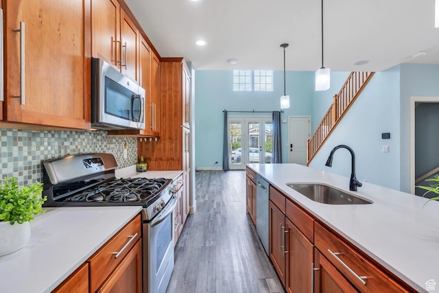 4489 W Milford Dr, South Jordan, UT 84009 - kitchen featuring wood finished floors, light countertops, tasteful backsplash, a sink, and appliances with stainless steel finishes