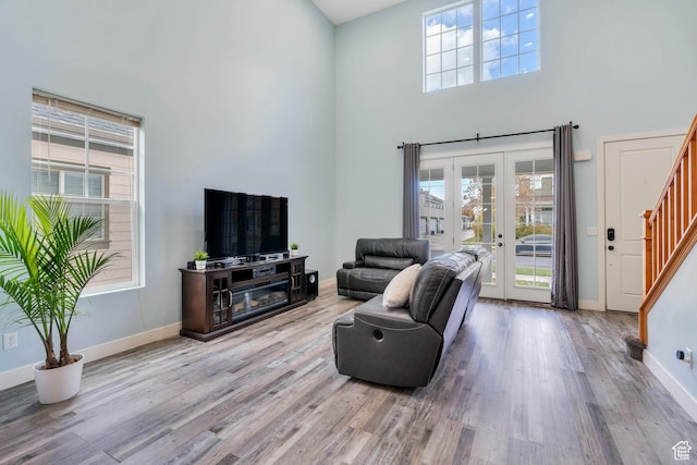 4489 W Milford Dr, South Jordan, UT 84009 - living room featuring wood finished floors, a high ceiling, a healthy amount of sunlight, and stairway