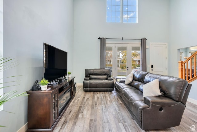 4489 W Milford Dr, South Jordan, UT 84009 - living area featuring stairs, baseboards, light wood finished floors, and a towering ceiling