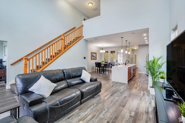 4489 W Milford Dr, South Jordan, UT 84009 - living area featuring light wood-type flooring, baseboards, stairs, and a high ceiling