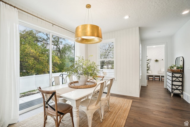 dining area featuring a textured ceiling, dark wood-style flooring, baseboards, and recessed lighting
