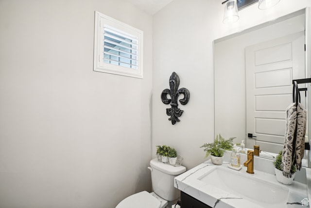 half bathroom featuring toilet and vanity