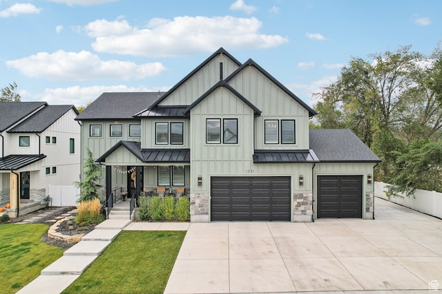 modern inspired farmhouse with fence, driveway, metal roof, board and batten siding, and a standing seam roof