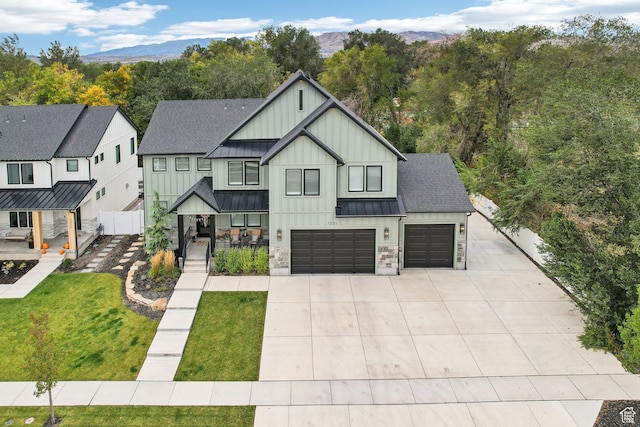 modern farmhouse with concrete driveway, board and batten siding, fence, and a standing seam roof