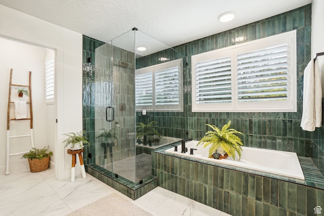 full bathroom with a garden tub, marble finish floor, and a stall shower
