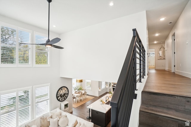 stairs with baseboards, wood finished floors, a ceiling fan, and recessed lighting