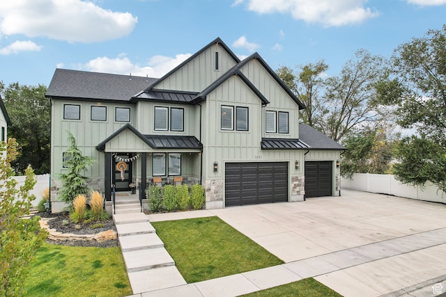 modern inspired farmhouse with concrete driveway, roof with shingles, fence, and a standing seam roof