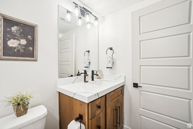 bathroom featuring toilet and vanity