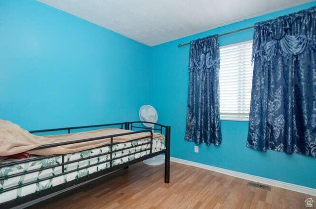 bedroom with wood finished floors and baseboards