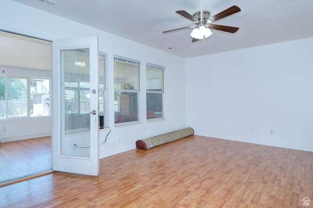 empty room featuring wood finished floors, ceiling fan, french doors, and baseboards