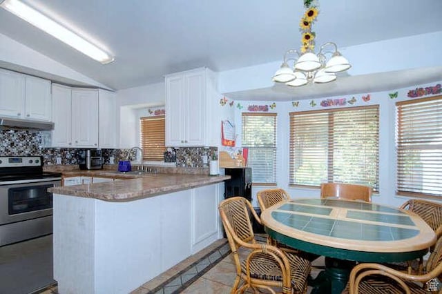 kitchen with under cabinet range hood, backsplash, white cabinets, lofted ceiling, and a peninsula
