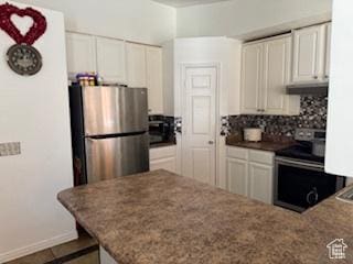 kitchen featuring appliances with stainless steel finishes, white cabinetry, tasteful backsplash, and a peninsula