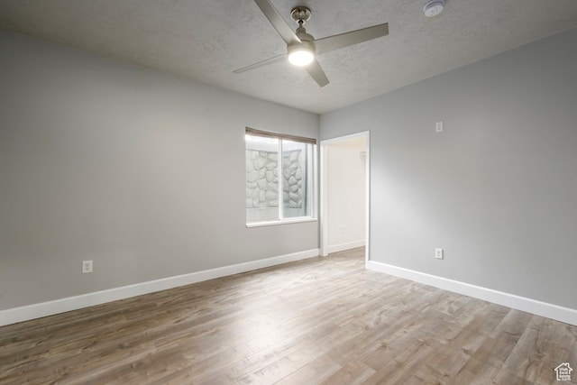unfurnished room with a ceiling fan, wood finished floors, baseboards, and a textured ceiling