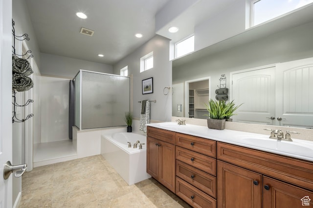 bathroom featuring visible vents, a shower stall, a garden tub, and a sink