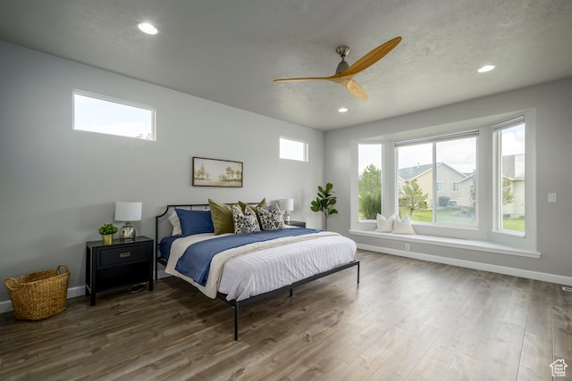 bedroom featuring recessed lighting, multiple windows, wood finished floors, and baseboards