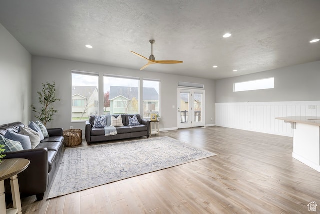 living area with a ceiling fan, recessed lighting, wood finished floors, and a textured ceiling
