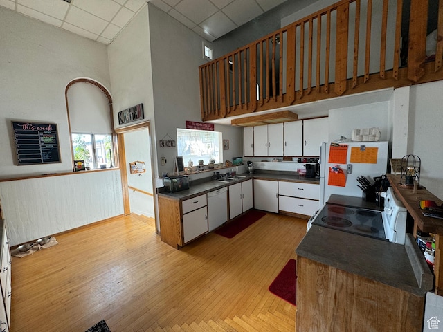 50 W 100 N, Salina, UT 84654 - kitchen featuring white appliances, a paneled ceiling, dark countertops, a towering ceiling, and light wood finished floors