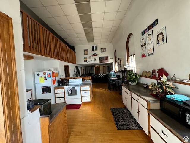 50 W 100 N, Salina, UT 84654 - kitchen featuring white appliances, dark countertops, light wood finished floors, arched walkways, and a drop ceiling