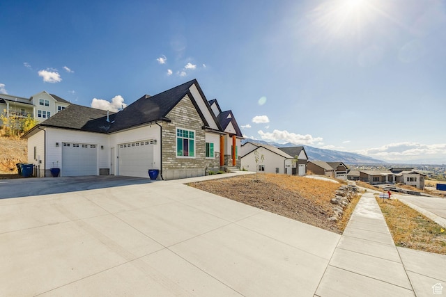104 S 950 E, Hyde Park, UT 84318 - view of property exterior featuring a garage, concrete driveway, stone siding, and a residential view