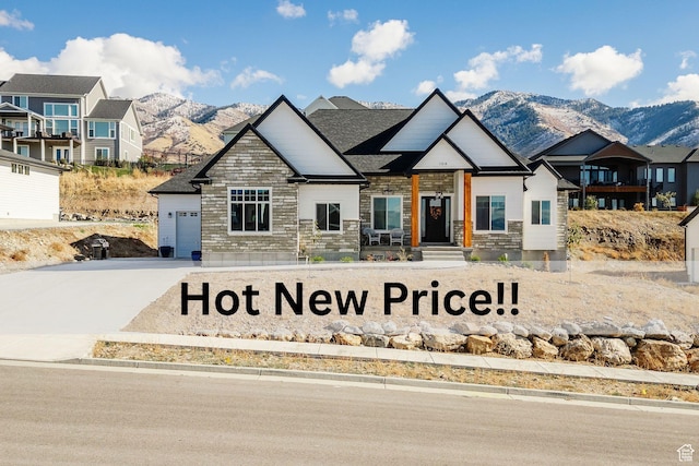 104 S 950 E, Hyde Park, UT 84318 - view of front of home featuring a mountain view, stone siding, and concrete driveway