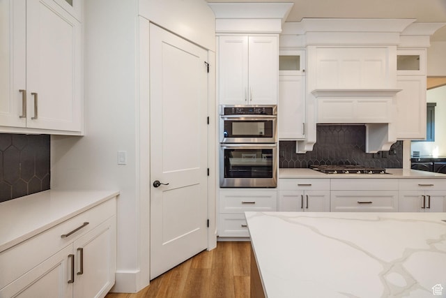 104 S 950 E, Hyde Park, UT 84318 - kitchen with double oven, white cabinets, tasteful backsplash, and gas cooktop