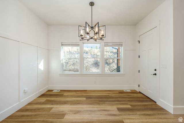 104 S 950 E, Hyde Park, UT 84318 - unfurnished dining area with a chandelier, baseboards, and light wood-type flooring