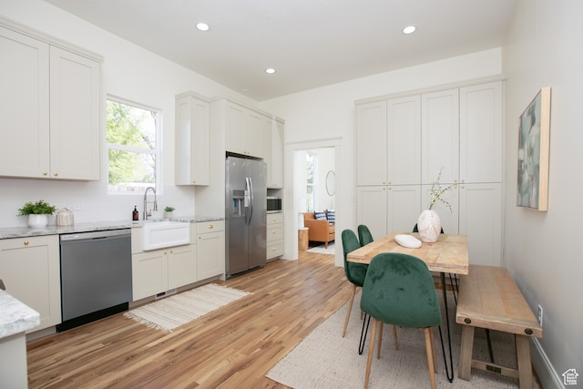 717 E Logan Ave, Salt Lake City, UT 84105 - kitchen with sink, appliances with stainless steel finishes, light hardwood / wood-style flooring, and white cabinets