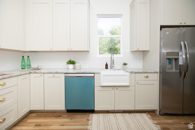 717 E Logan Ave, Salt Lake City, UT 84105 - kitchen featuring light stone countertops, appliances with stainless steel finishes, sink, and light wood-type flooring