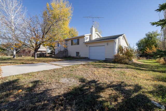 1390 N 500 W, Vernal, UT 84078 - rear view of property featuring a garage, a yard, a chimney, and concrete driveway
