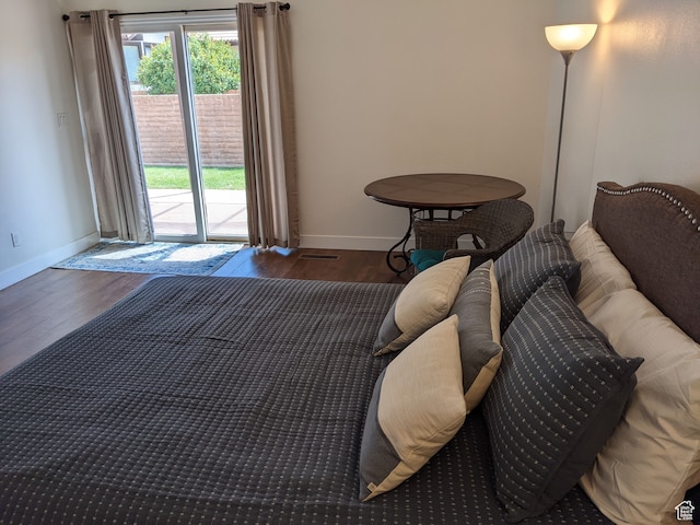 bedroom with dark wood-type flooring and access to outside