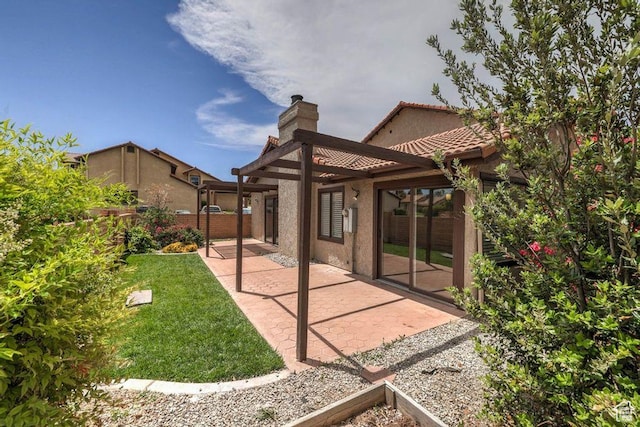 back of property with a patio and a lawn