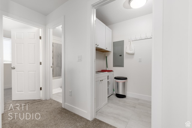 hallway featuring electric panel and light colored carpet
