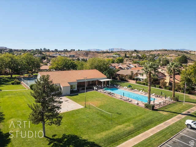 view of pool with a patio area, a mountain view, and a yard