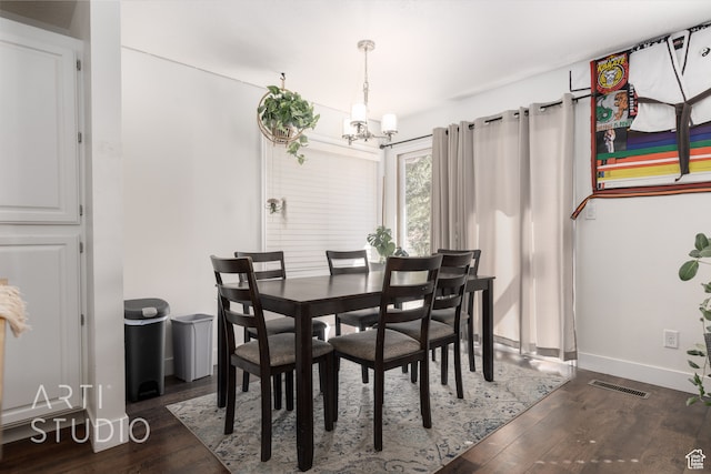 dining room featuring dark hardwood / wood-style floors and a chandelier