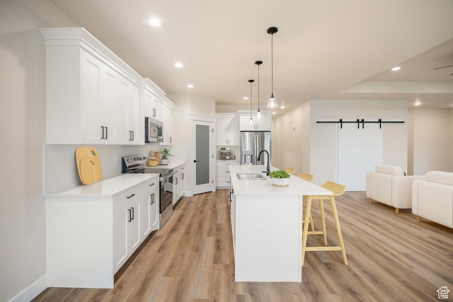 447 S 580 W, Providence, UT 84332 - kitchen with stainless steel appliances, a sink, a breakfast bar area, recessed lighting, and light wood finished floors