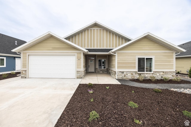 447 S 580 W, Providence, UT 84332 - view of front of property with stone siding, a garage, driveway, and board and batten siding