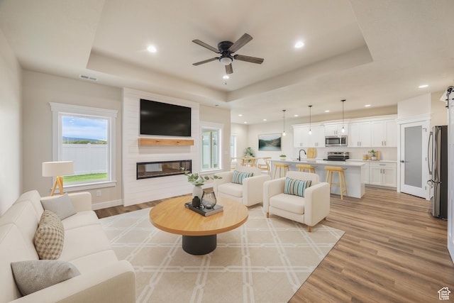 447 S 580 W, Providence, UT 84332 - living area with a raised ceiling, recessed lighting, a ceiling fan, light wood finished floors, and a large fireplace