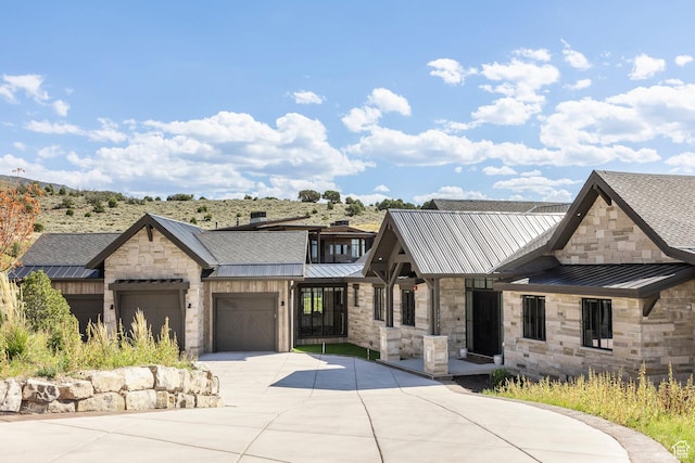 1254 N Explorer Peak Cir, Heber City, UT 84032 - view of front of home with metal roof, a garage, stone siding, driveway, and a standing seam roof