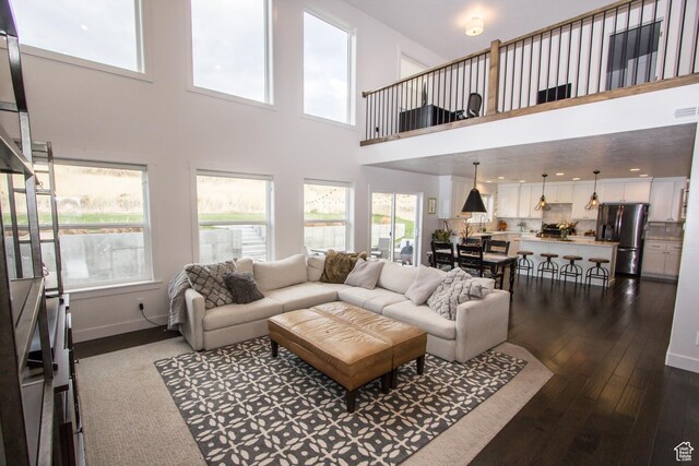 520 N 900 E, Hyde Park, UT 84318 - living room featuring dark wood-type flooring, a towering ceiling, and baseboards