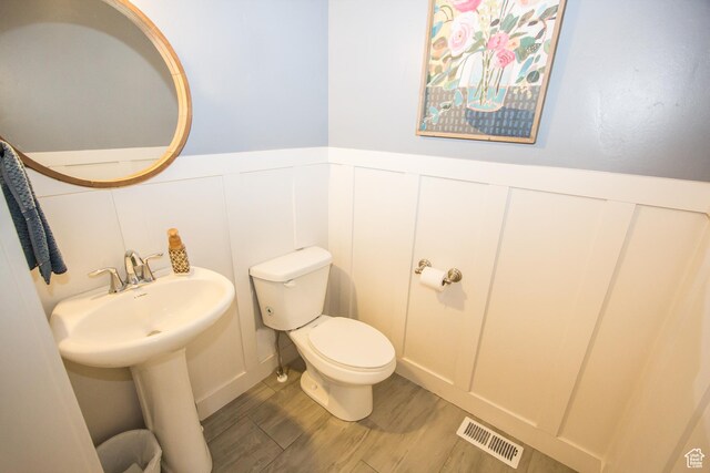 520 N 900 E, Hyde Park, UT 84318 - bathroom with a decorative wall, toilet, wood finished floors, and a wainscoted wall