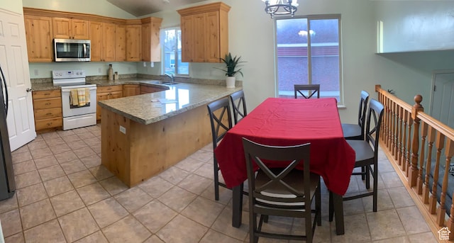 642 W 1150th St S, Provo, UT 84601 - kitchen with white range with electric stovetop, stainless steel microwave, a sink, a peninsula, and vaulted ceiling